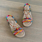 Rainbow boho t-strap sandals pair flatlay on wood floor - Smollz SA